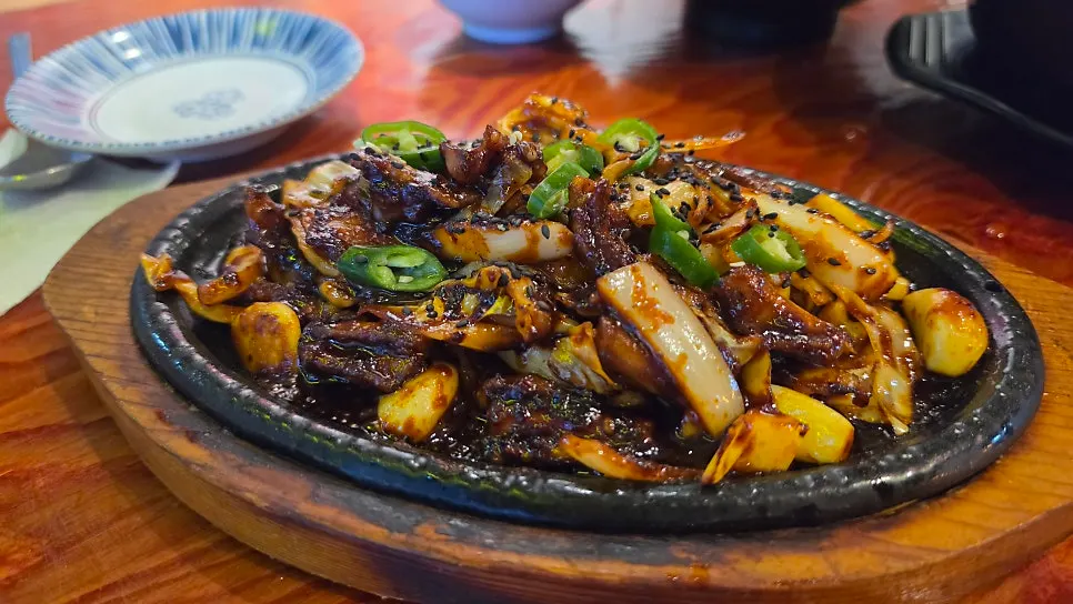 Fire-grilled eel stir-fry topped with vegetables and chili peppers