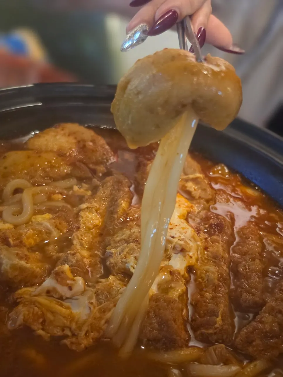 김치전골 국물에 담긴 우동면과 계란