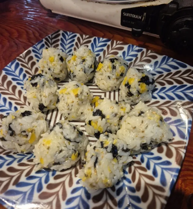 Rice ball topped with seaweed flakes and mayonnaise