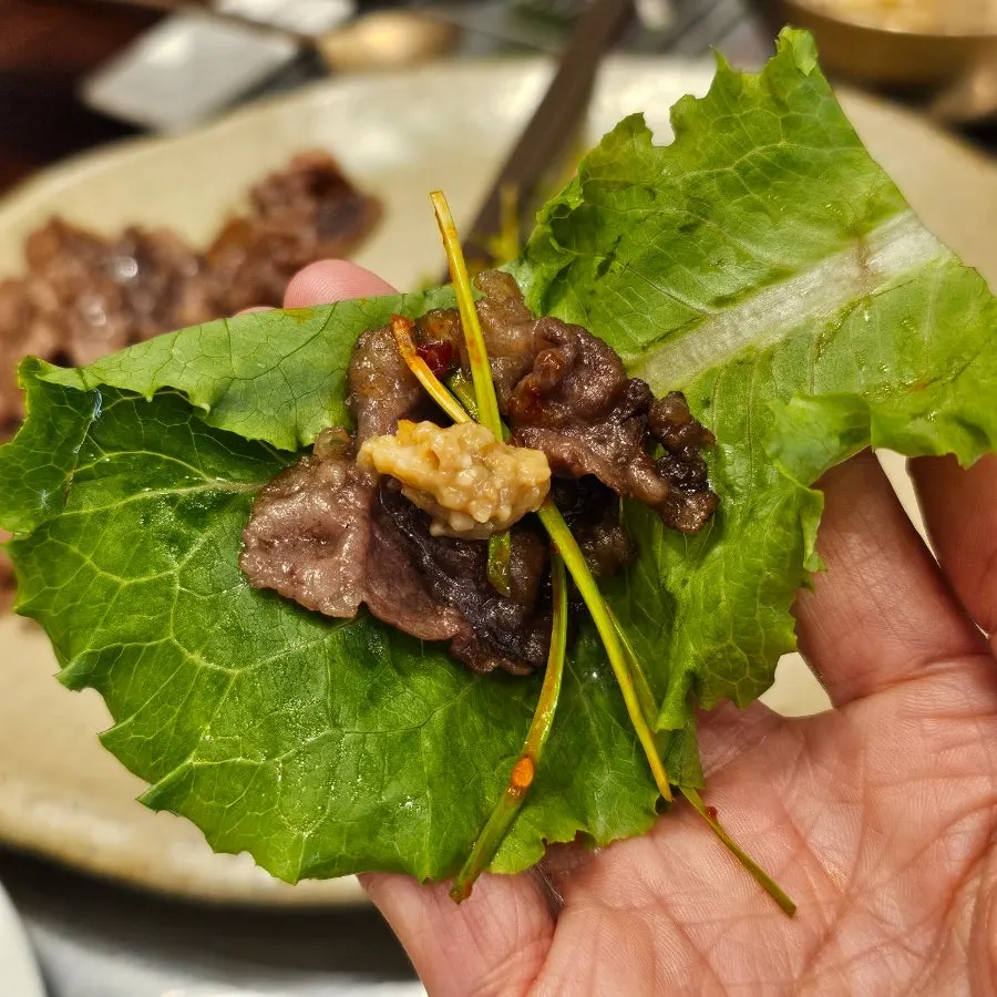 Bulgogi plated with scallion salad and lettuce wraps
