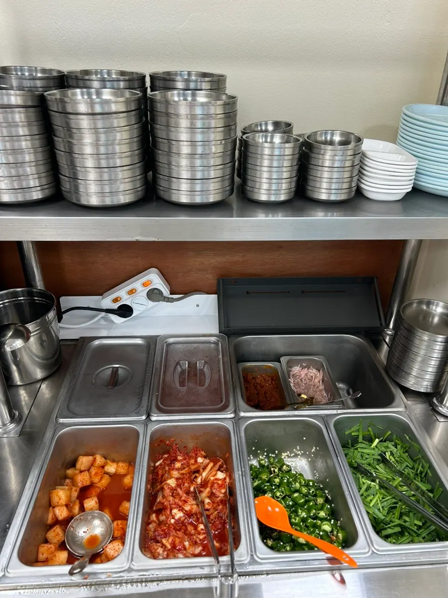 Self-serve bar at Gaeryeong Gukbap with kimchi and salted shrimp