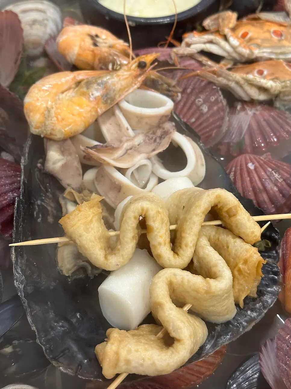 Fish cake, squid, and shrimp piled on a shell in the center