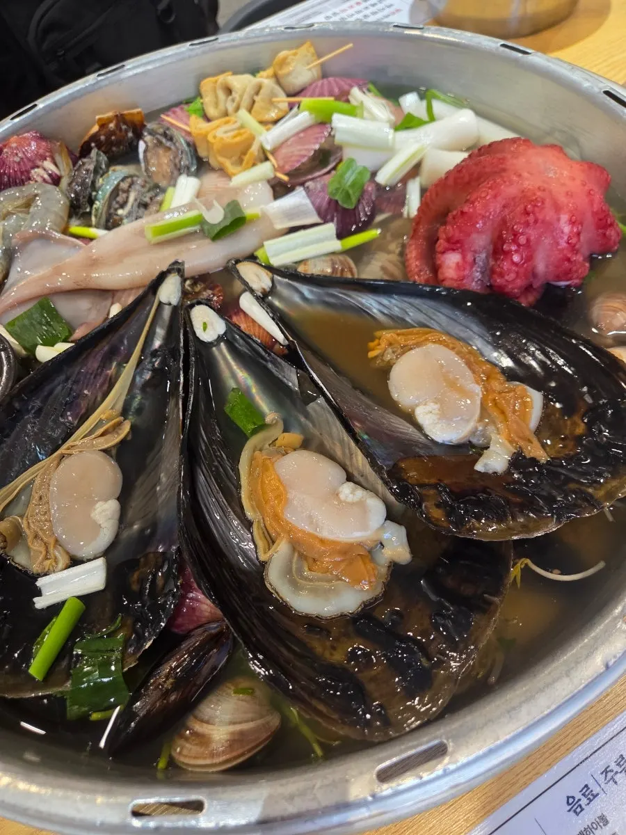Hot pot filled with razor clams, abalone, and scallops