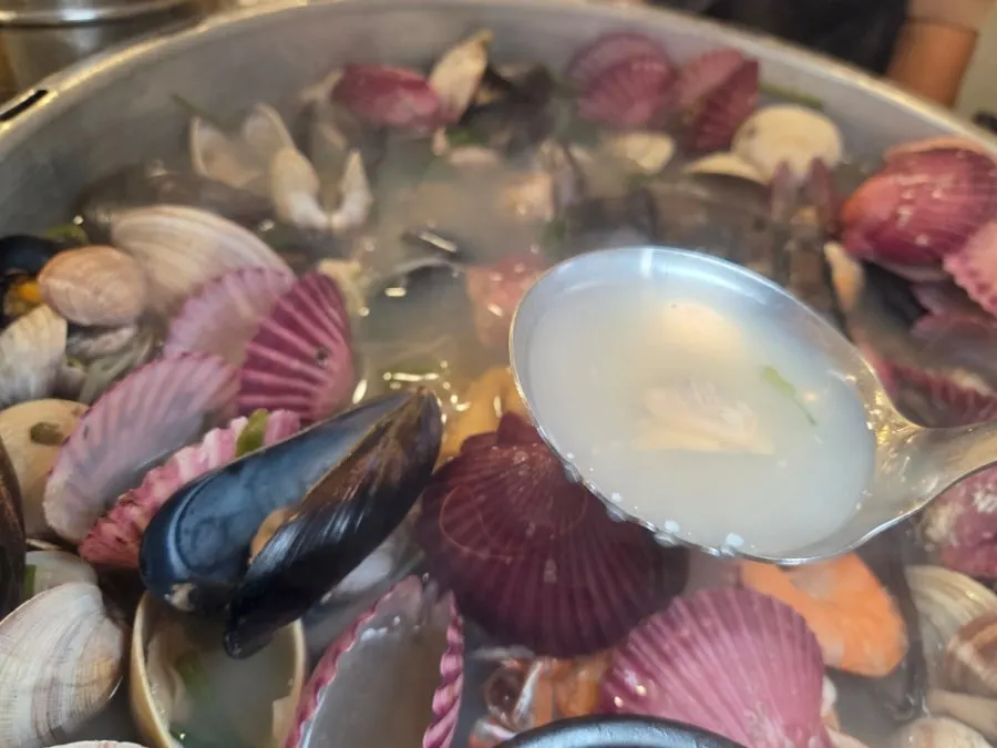 Clear-broth hot pot with squid and scallop cut up by the owner