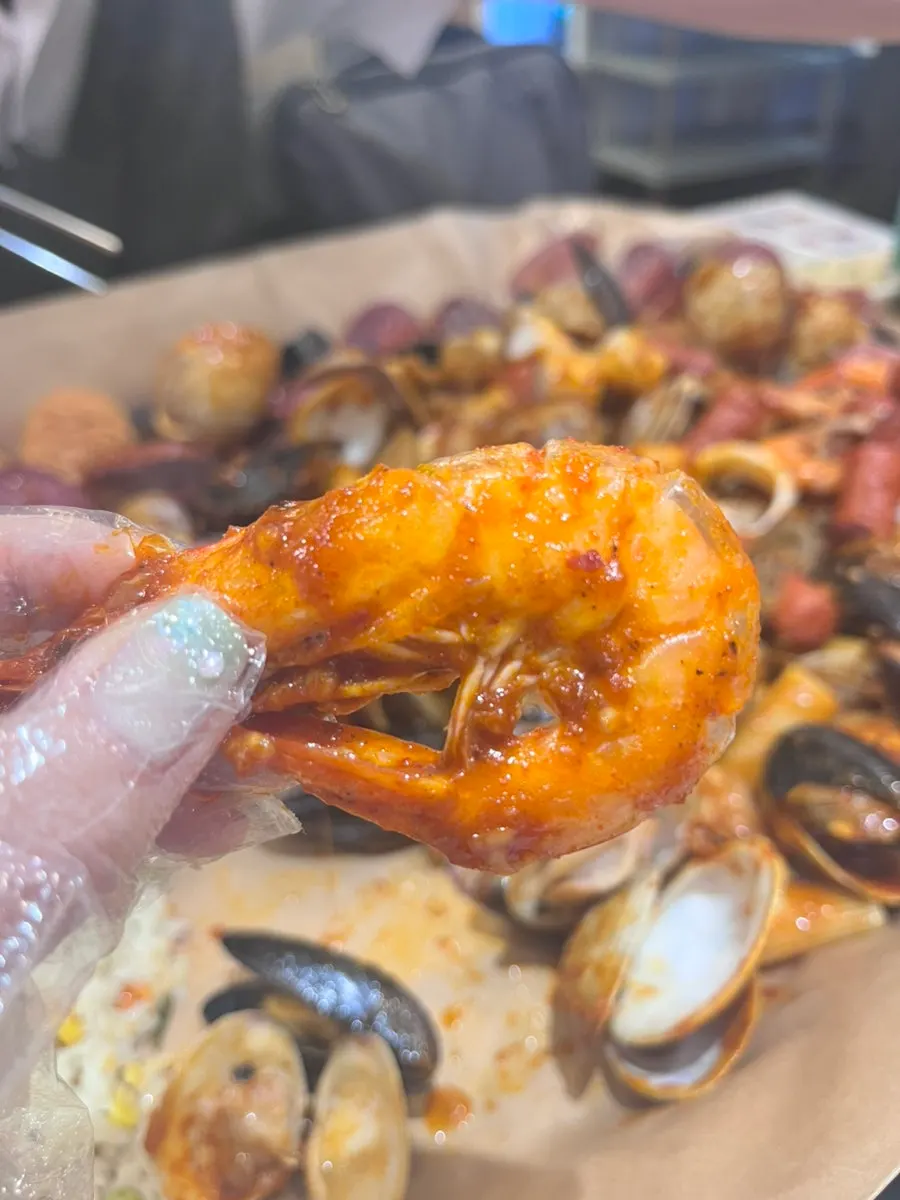 Prying open shells to eat the seafood boiling clams