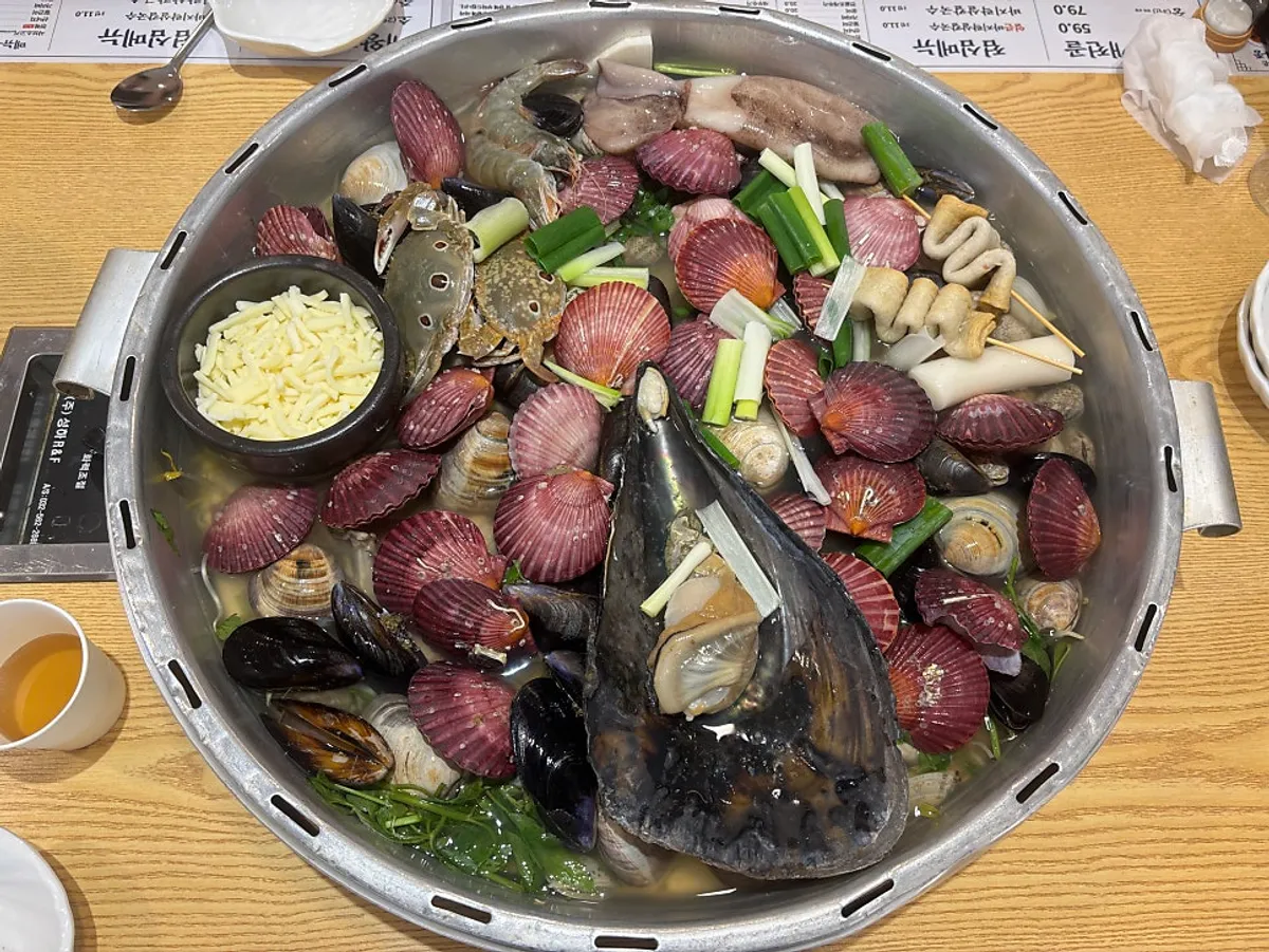 Giant clam hot pot for two piled high in a large pot