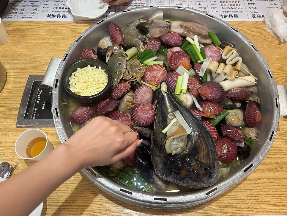 Hot pot filled with scallops, mussels, hard clams and fan mussel