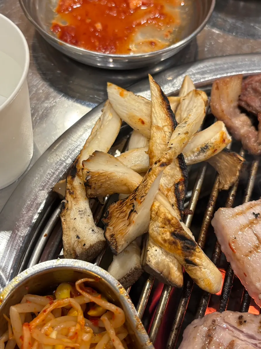 King oyster mushroom grilled golden brown over charcoal