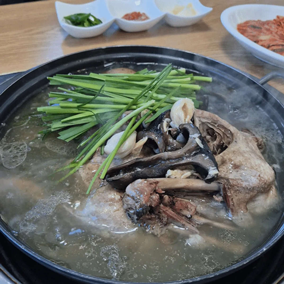 부추와 능이버섯이 가득 올라간 오리 능이백숙 냄비