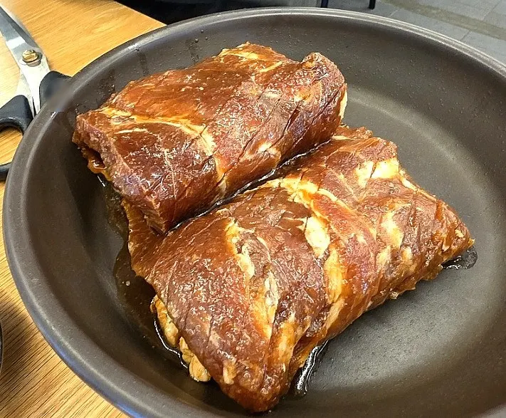Thick handmade king pork ribs plated with sauce packed into the meat