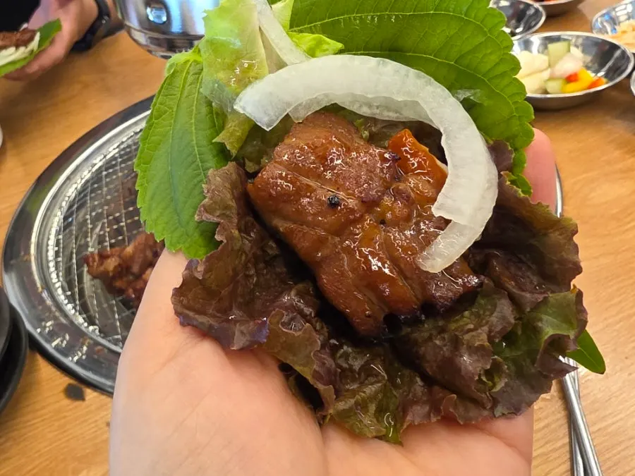 Lettuce wrap topped with pork ribs, onion, and garlic
