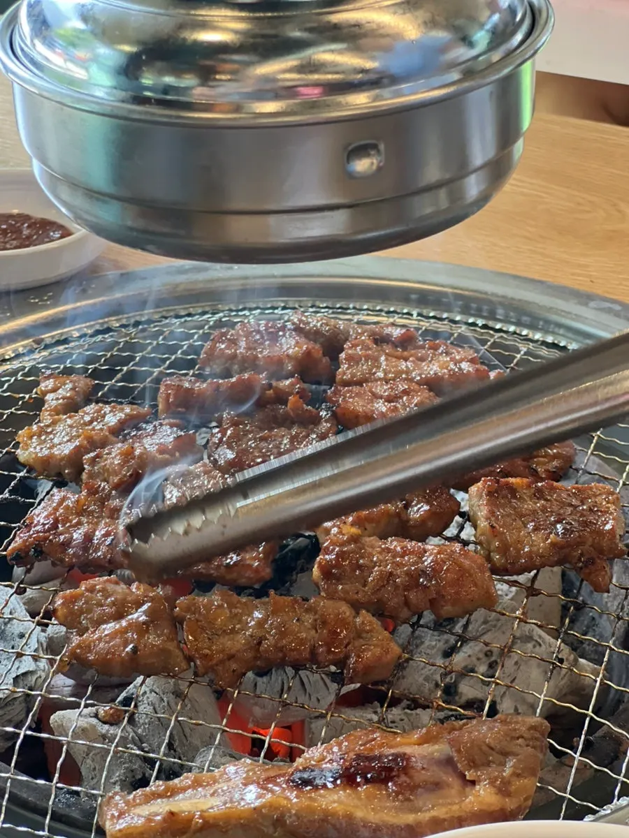 Marinated king pork ribs on a charcoal grill grate