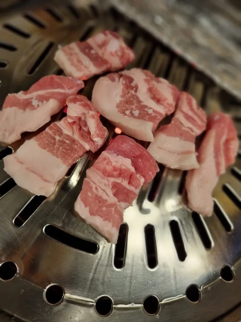 Charcoal salt-crusted pork belly sprinkled with coarse salt