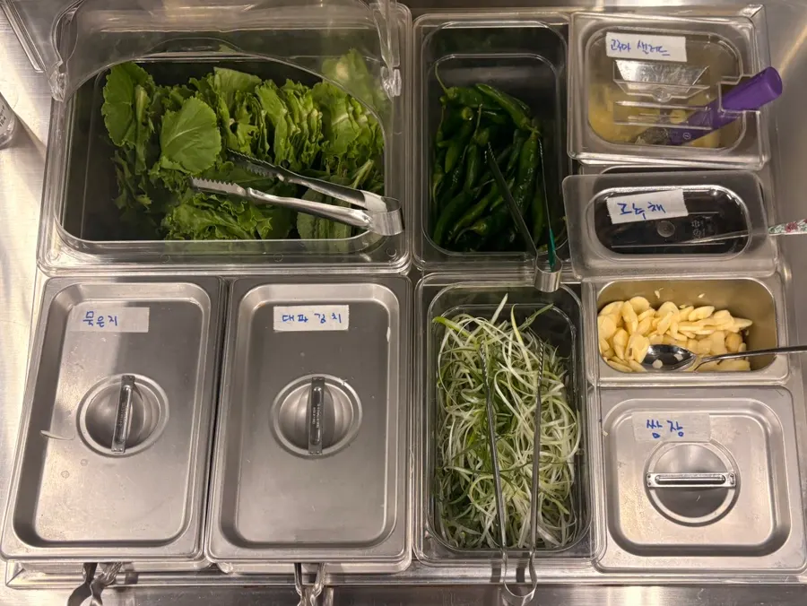 Self-serve bar with aged kimchi, green onion kimchi, and shredded green onions