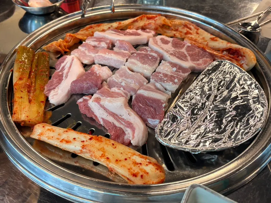 Grill plate with green onion kimchi and aged kimchi cooking together