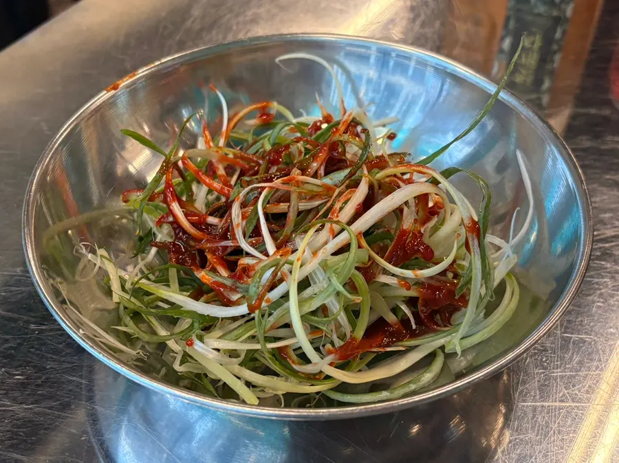 Grilled meat topped with shredded green onions from the self-serve bar