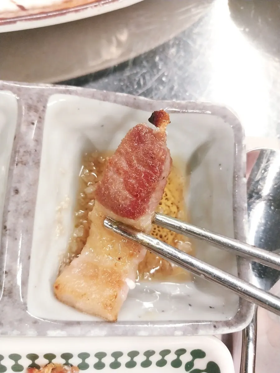 A piece of pork belly picked up with ssamjang