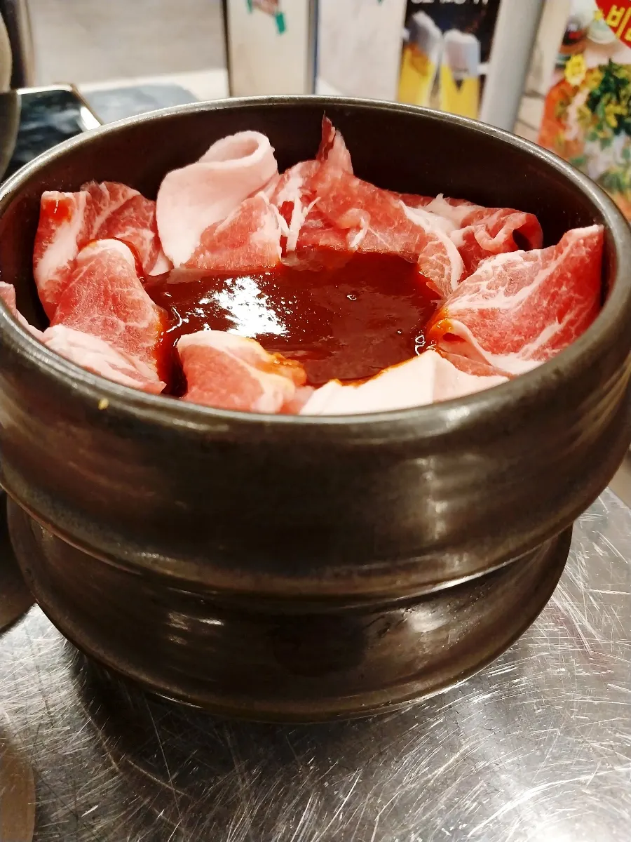 Gochujang charcoal bulgogi served in a small earthenware jar