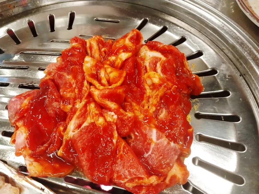 Gochujang charcoal bulgogi cooking on the grill plate
