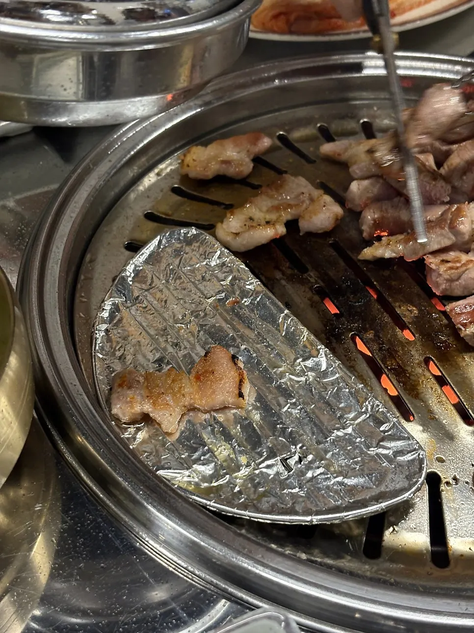 연탄불에 올린 삼겹살과 김치, 대파