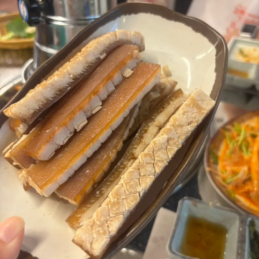 Wrapping meat with the flat bibim noodles