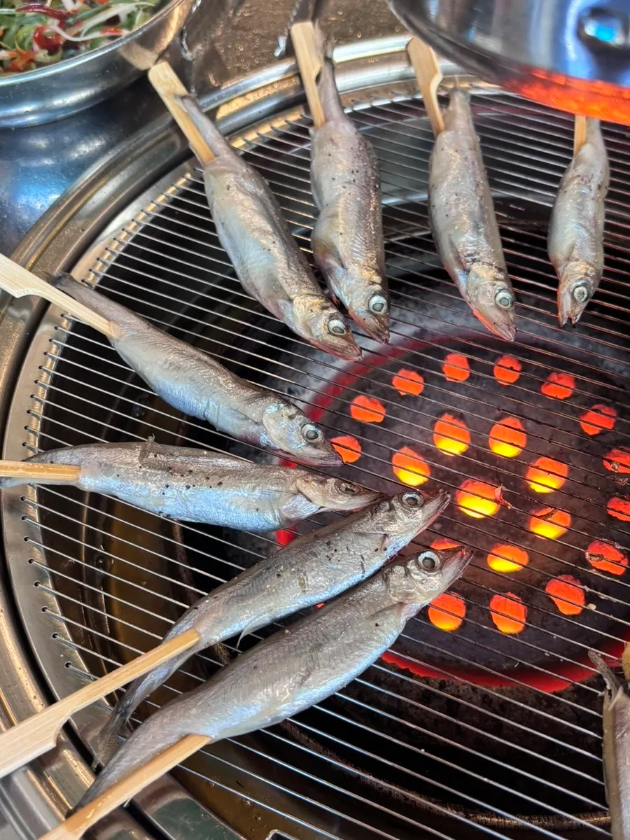 Capelin skewers grilled over charcoal