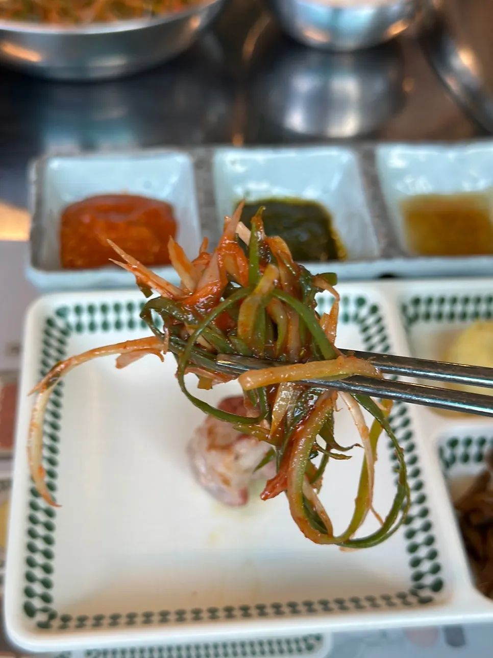 A piece of teukmoksal dipped in sesame oil sauce