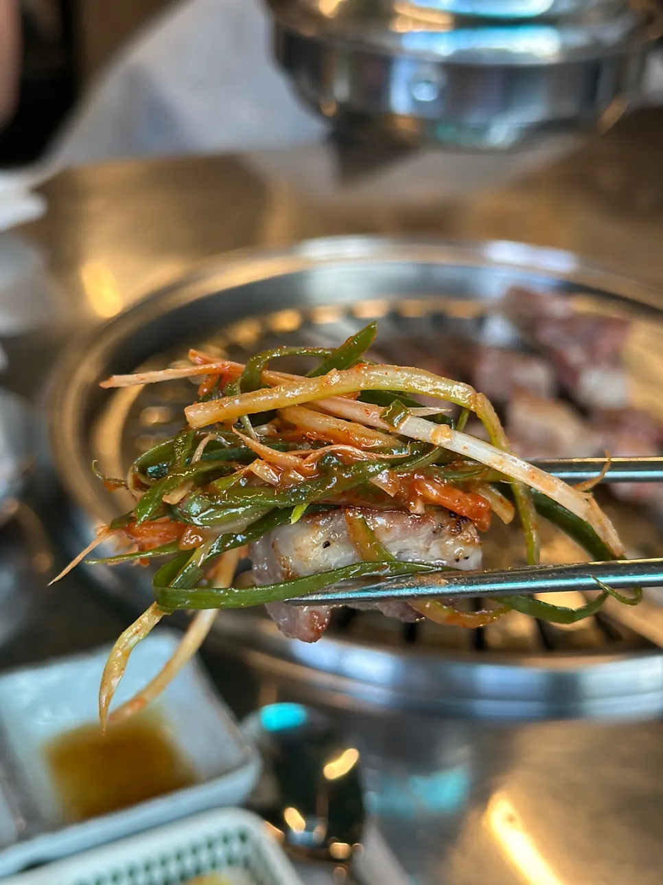 Grilled pork neck served with sauces on a small plate