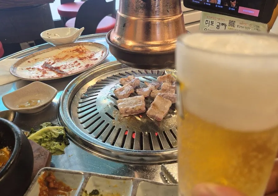 Draft beer glass next to grilled meat