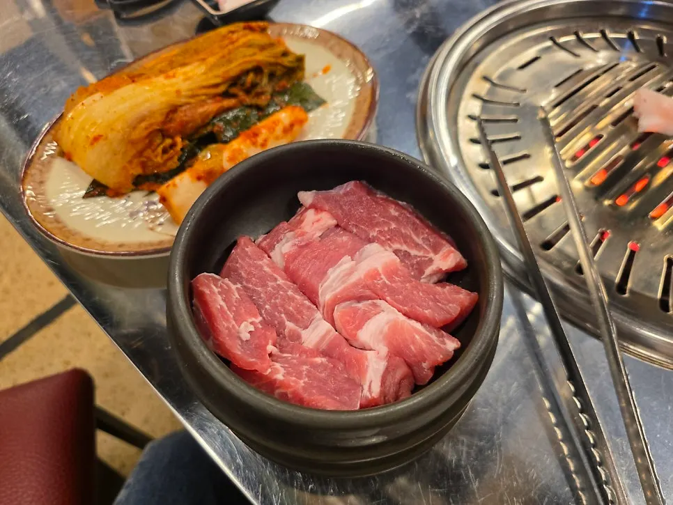 Pork belly grilling over a charcoal grill