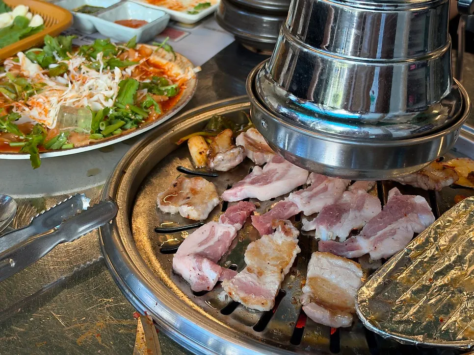 고기 한 점에 납작비빔면을 올린 모습