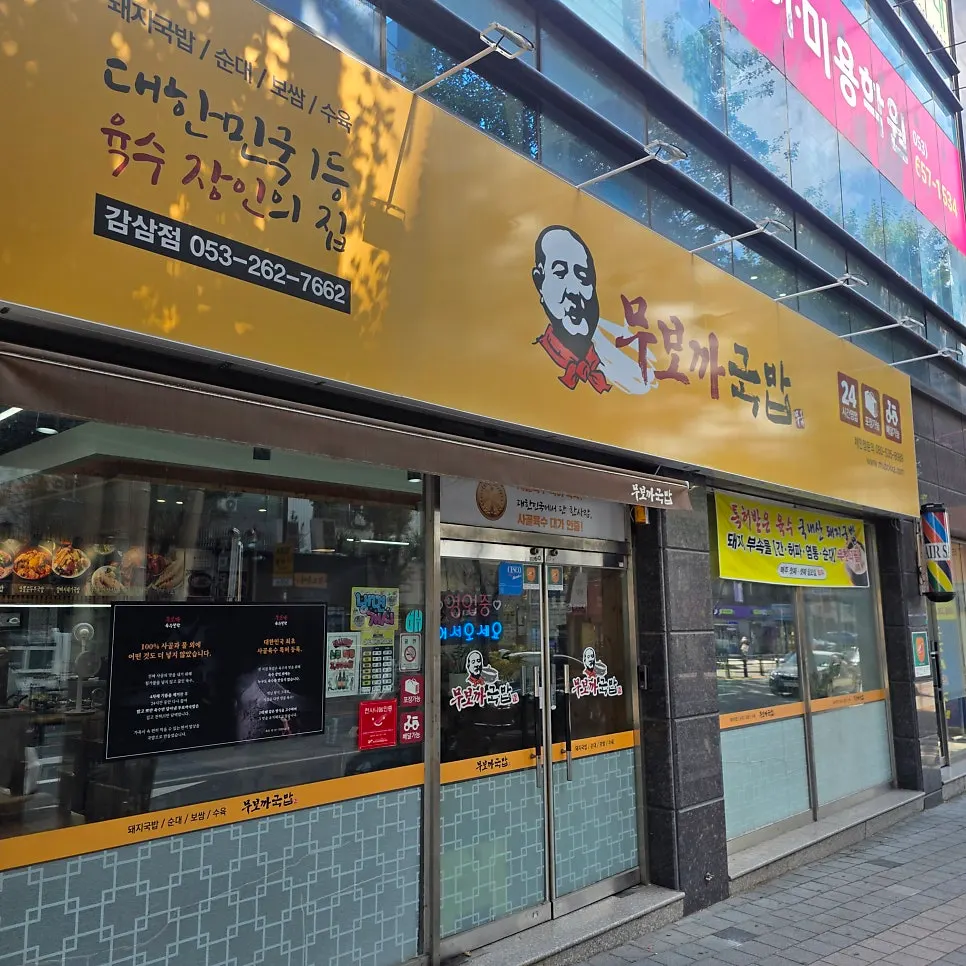 한우 사골육수 안내가 걸린 무보까국밥 감삼점 외벽