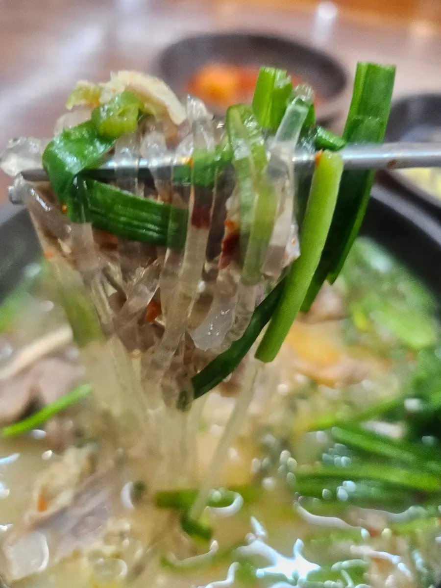 부추무침을 넣어 섞은 순대국밥