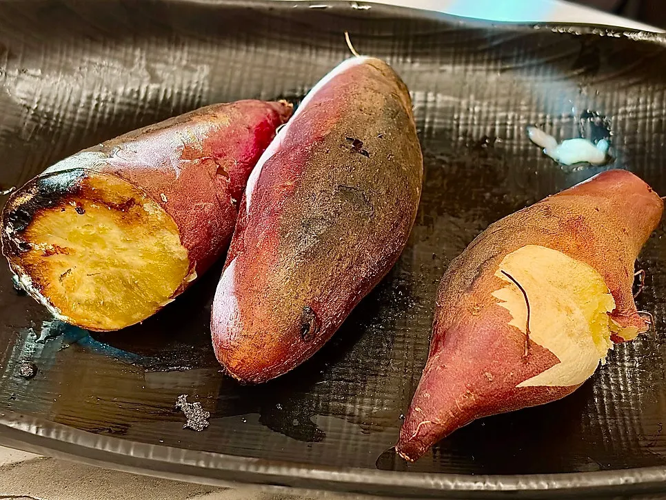 Foil-wrapped sweet potato roasted on charcoal