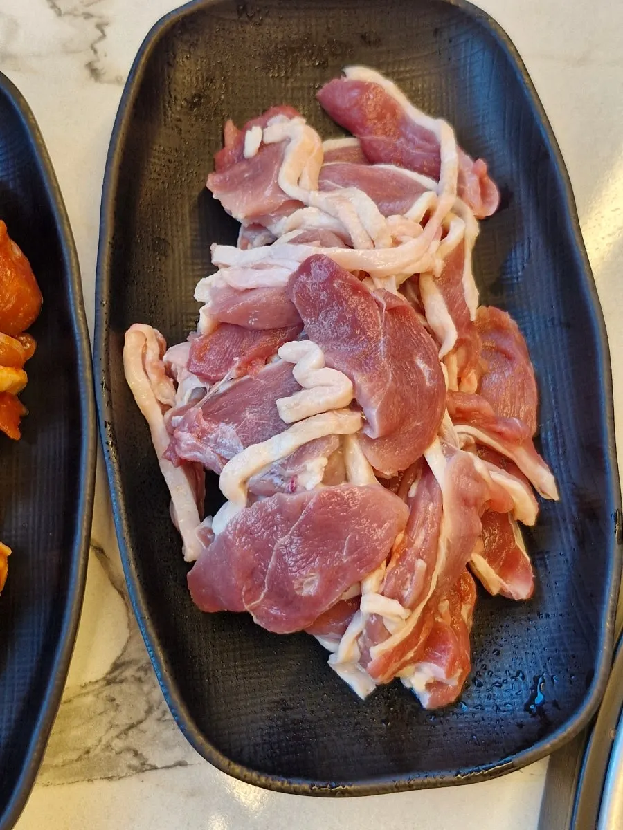 상에 차려진 반찬과 오리고기 접시