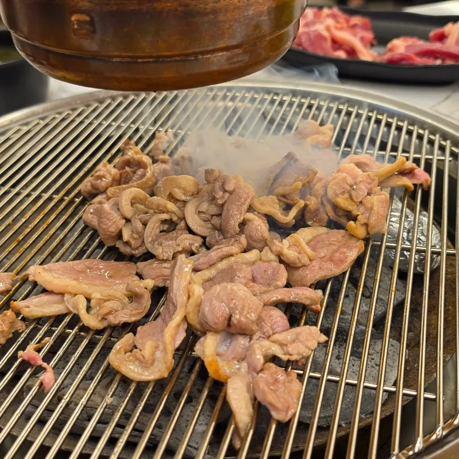Duck meat grilling over charcoal