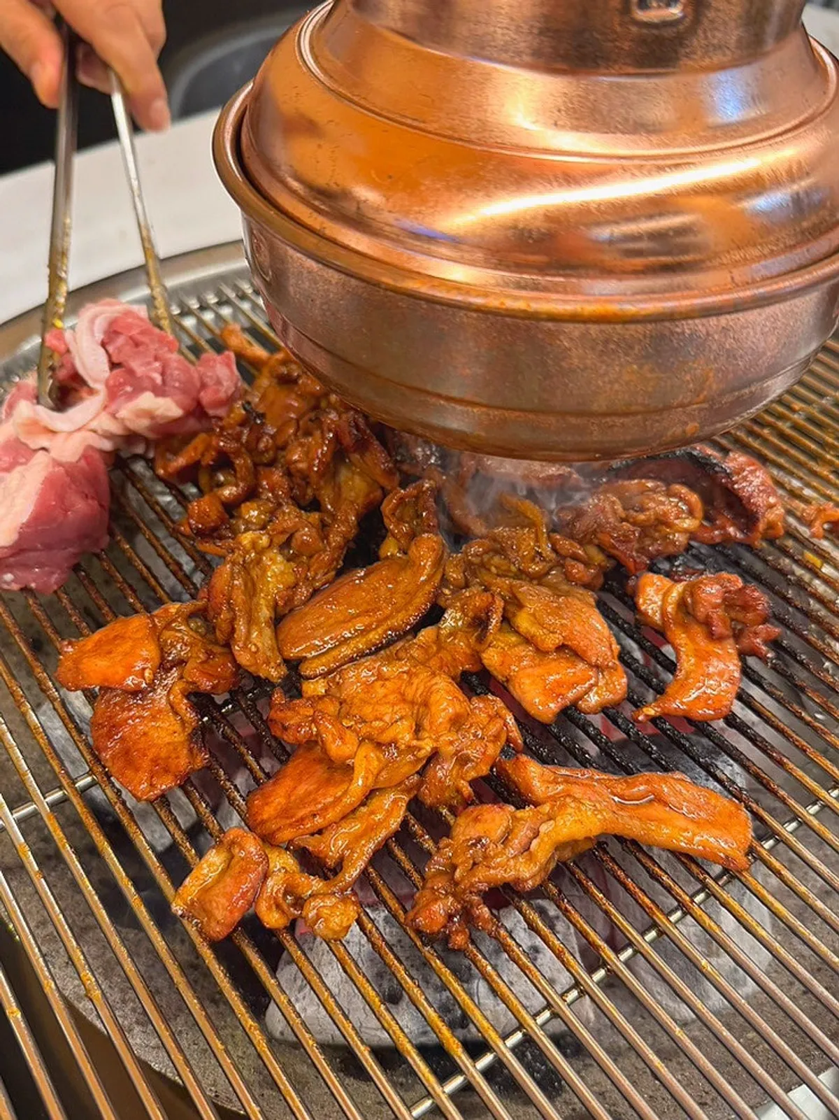 Spicy stir-grilled duck cooking on the charcoal grill