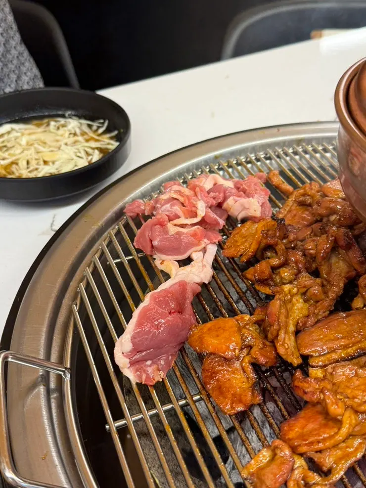 Close-up of the spicy stir-grilled duck cooking on the grill plate