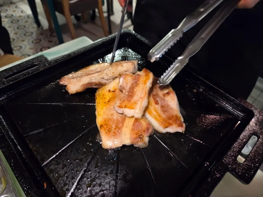 Two servings of samgyeopsal served with a lid on