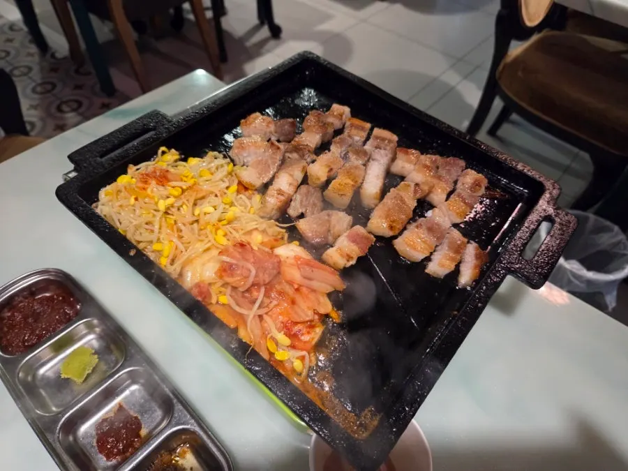 Samgyeopsal grilling with bean sprouts and kimchi on the tabletop grill