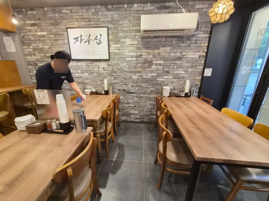 The interior with gray brick walls and wooden tables