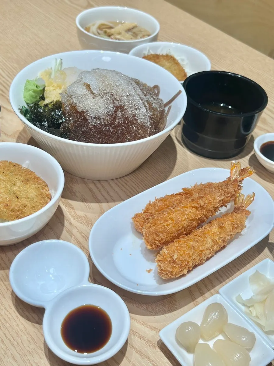 Table with croquette, fried shrimp, and cold soba