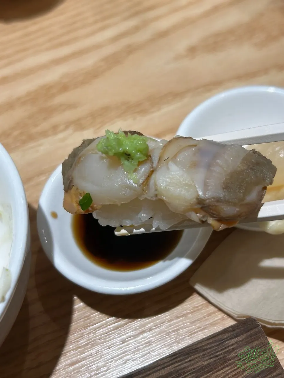 Salmon sushi topped with onion and sauce