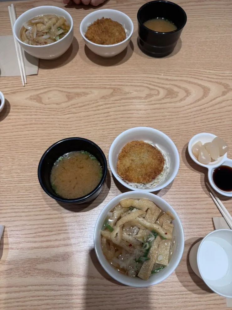 Table spread with soybean paste soup, croquette, salad, and mini udon