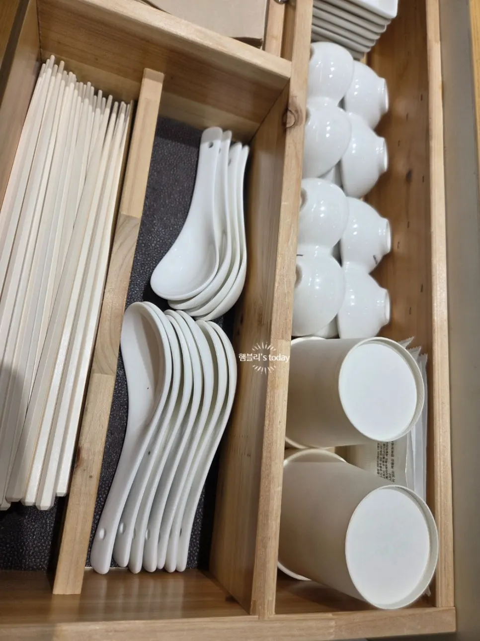 테이블 아래 정렬된 종이컵과 수저, 물티슈