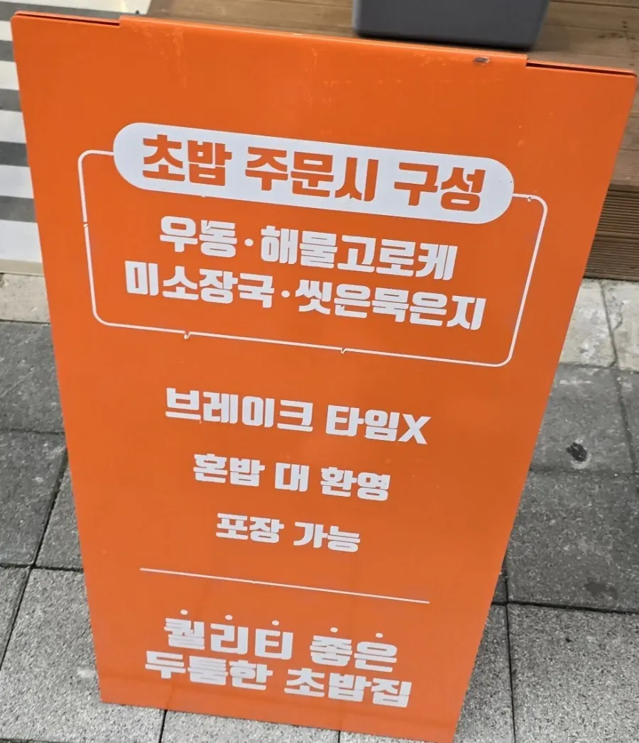 Sign near the entrance welcoming solo diners and offering takeout