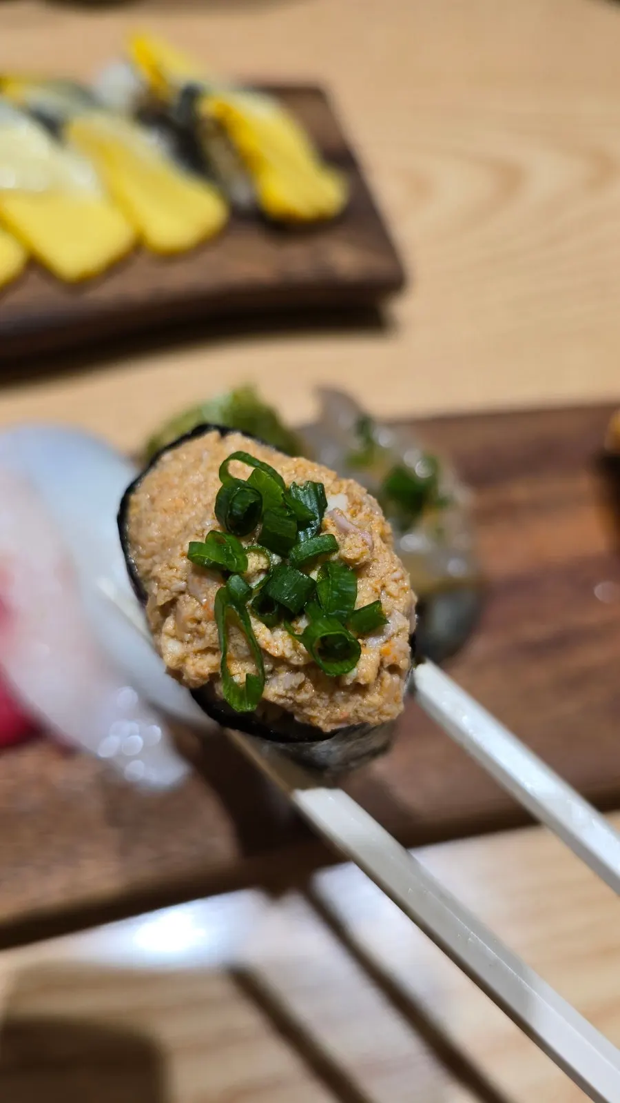 Close-up of gunkan sushi topped with scallion