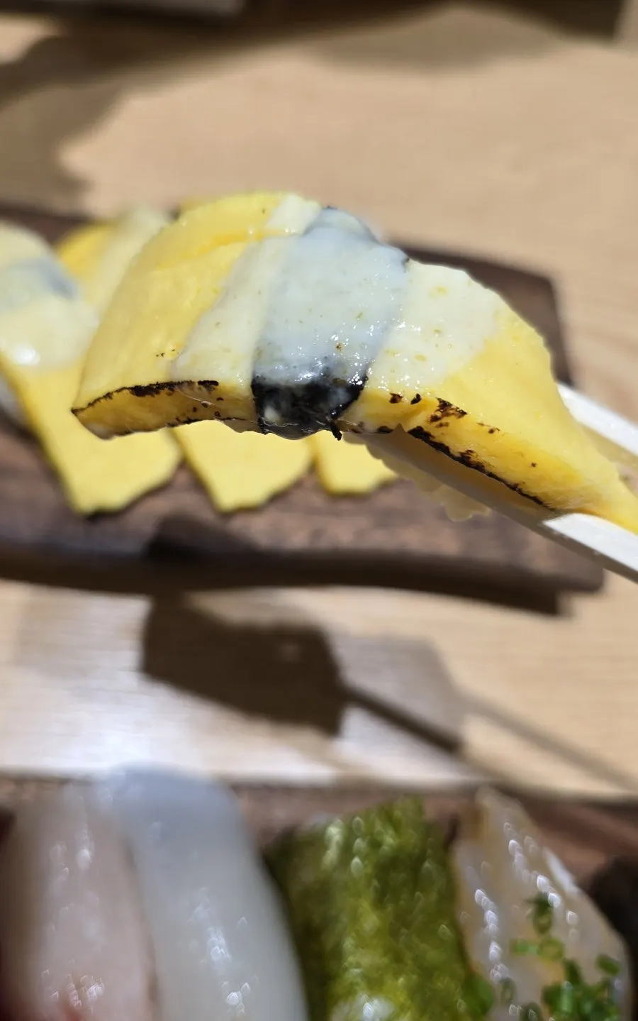 A piece of sushi topped with thick sliced fish