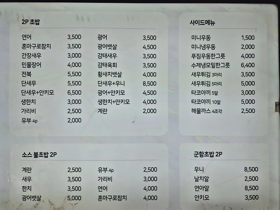 세트메뉴와 단품 2피스 초밥이 적힌 메뉴판