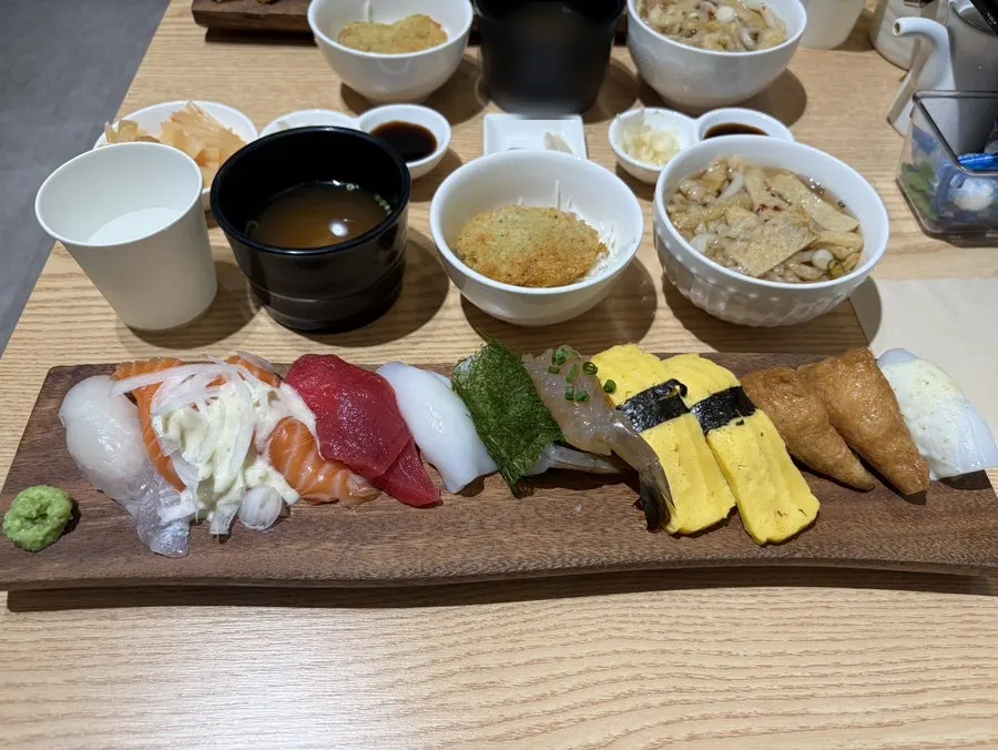 12 pieces of sushi with miso soup and mini udon on the table